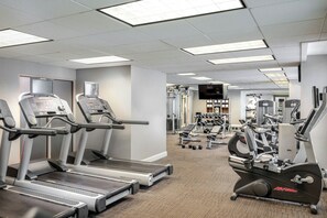 A gym with treadmills, elliptical machines, and weight equipment.