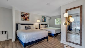A hotel room with two beds, a large mirror, and artwork on the walls. - Endless Dunes, A Modern Motel (Eastham)