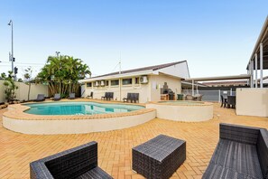A pool area with two pools, lounge chairs, and a covered seating area. - Sunnybank Star Hotel & Apartments (Eight Mile Plains)