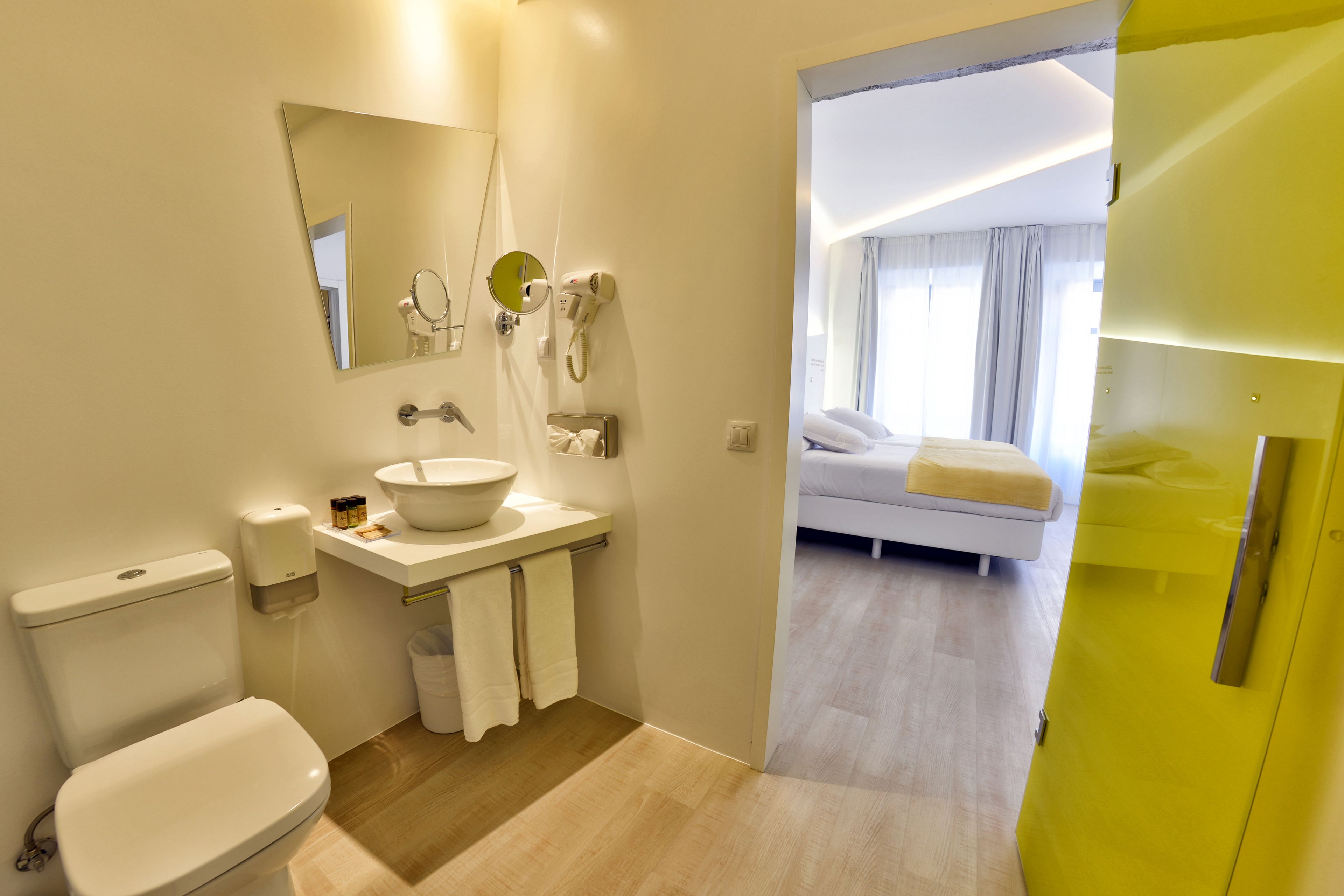 A modern bathroom with a toilet, sink, and mirror.