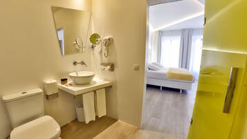 A modern bathroom with a toilet, sink, and mirror.
