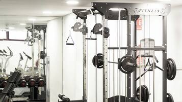 Un gimnasio con equipo de levantamiento de pesas, espejos y un diseño moderno y limpio.