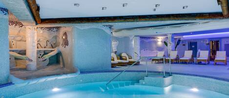 Zona de piscina con suelo de baldosas, una escalera que lleva a un nivel superior y varias sillas de descanso.