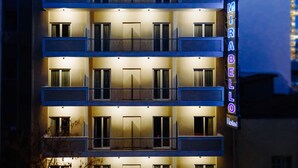 A multi-story hotel with balconies and a neon sign. - The Athens Mirabello (Athens)