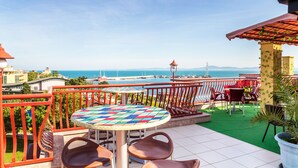 A terrace with a round table and chairs, overlooking a marina with boats and a clear sky. - Saint George Hotel & Spa (Pomorie)