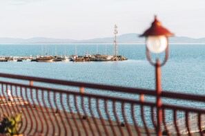 A pier with boats and a tall structure, viewed from a distance with a railing in the foreground. - Saint George Hotel & Spa (Pomorie)