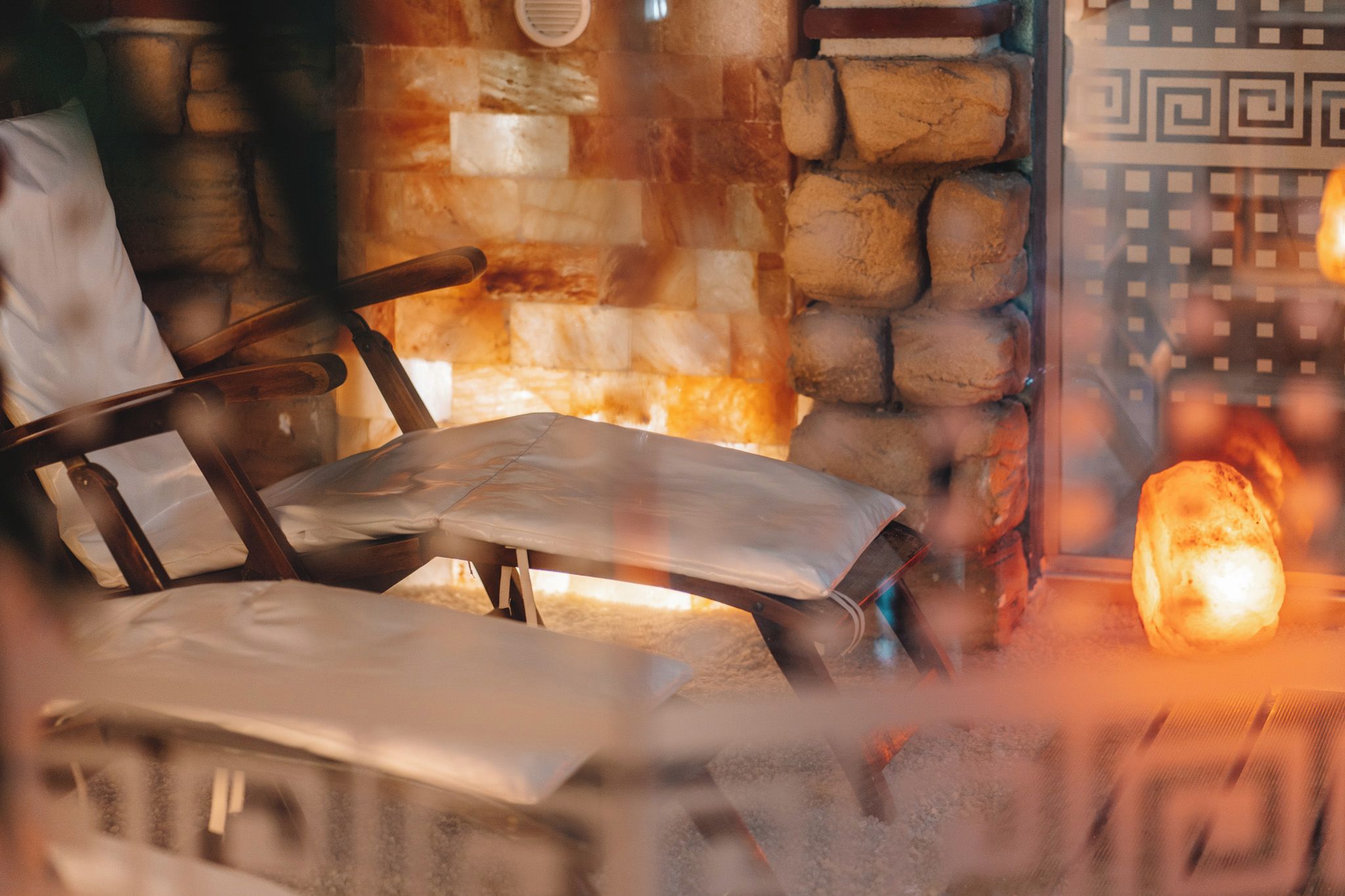 A stone fireplace with a bench in front.