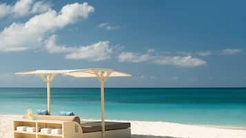 On the beach, white sand, beach cabanas, sun-loungers