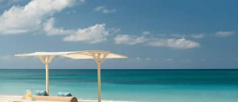 On the beach, white sand, beach cabanas, sun loungers