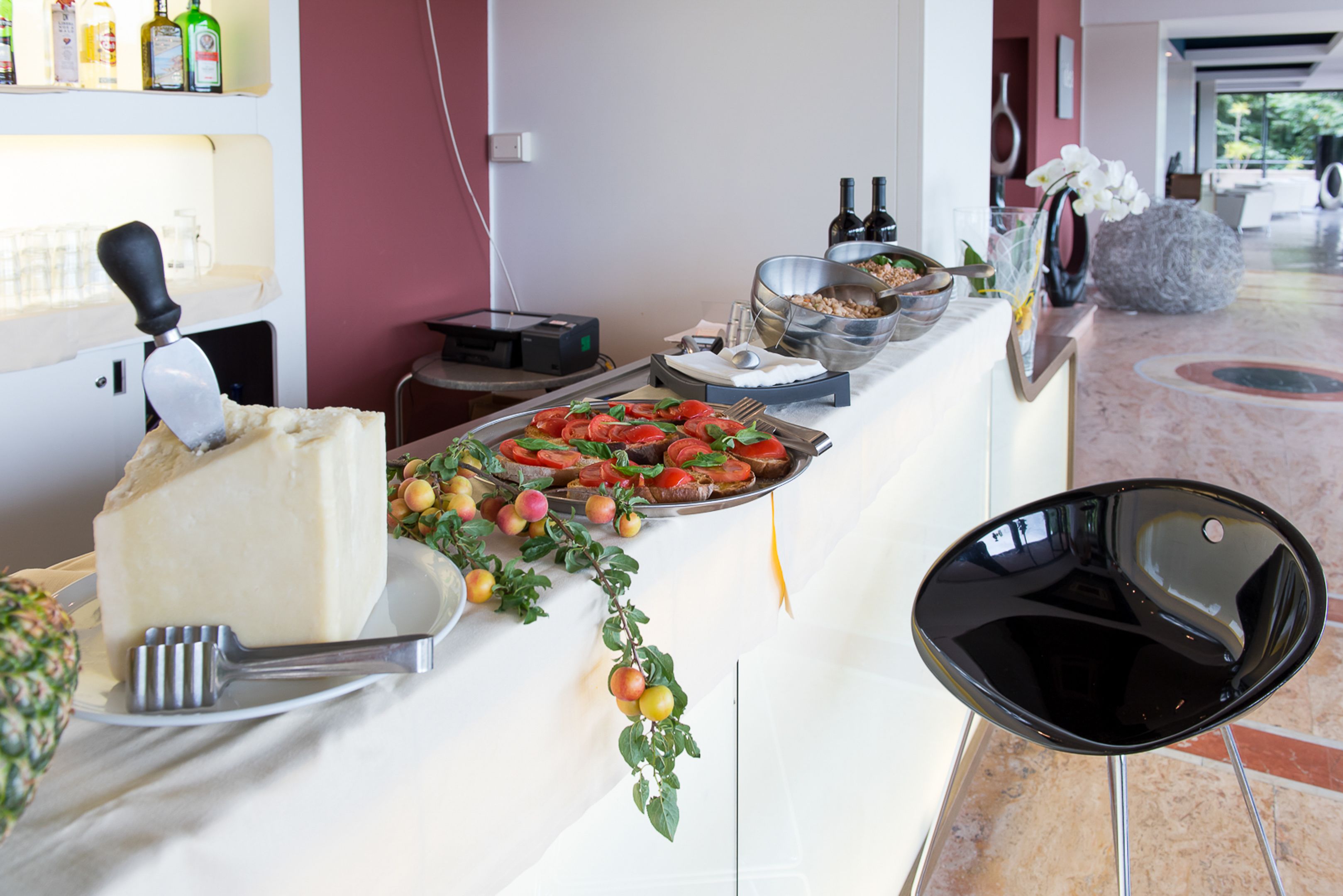 A buffet setup with various food items, a cake, and a bottle of wine.