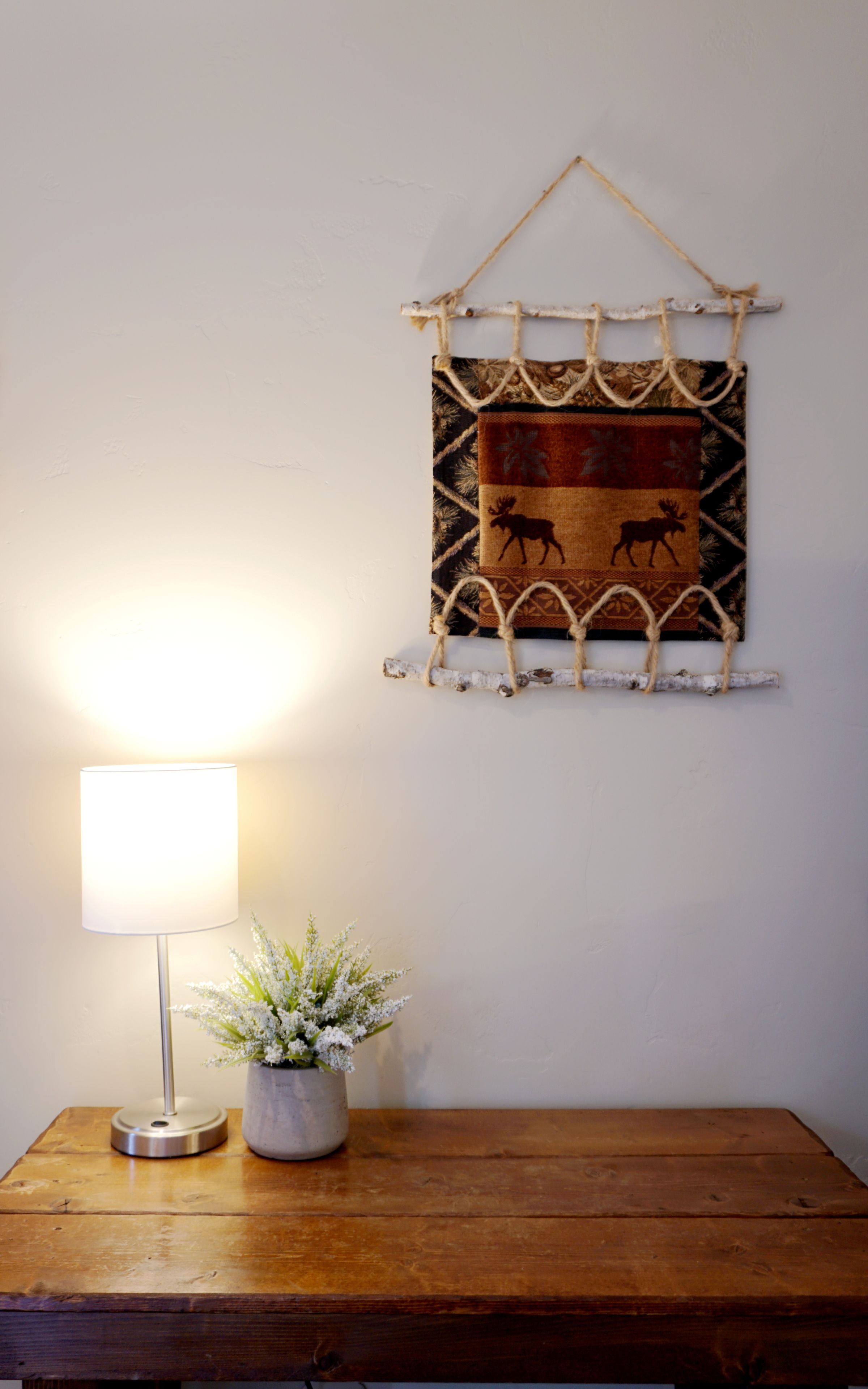 Una mesa de madera con una lámpara y una planta en maceta.