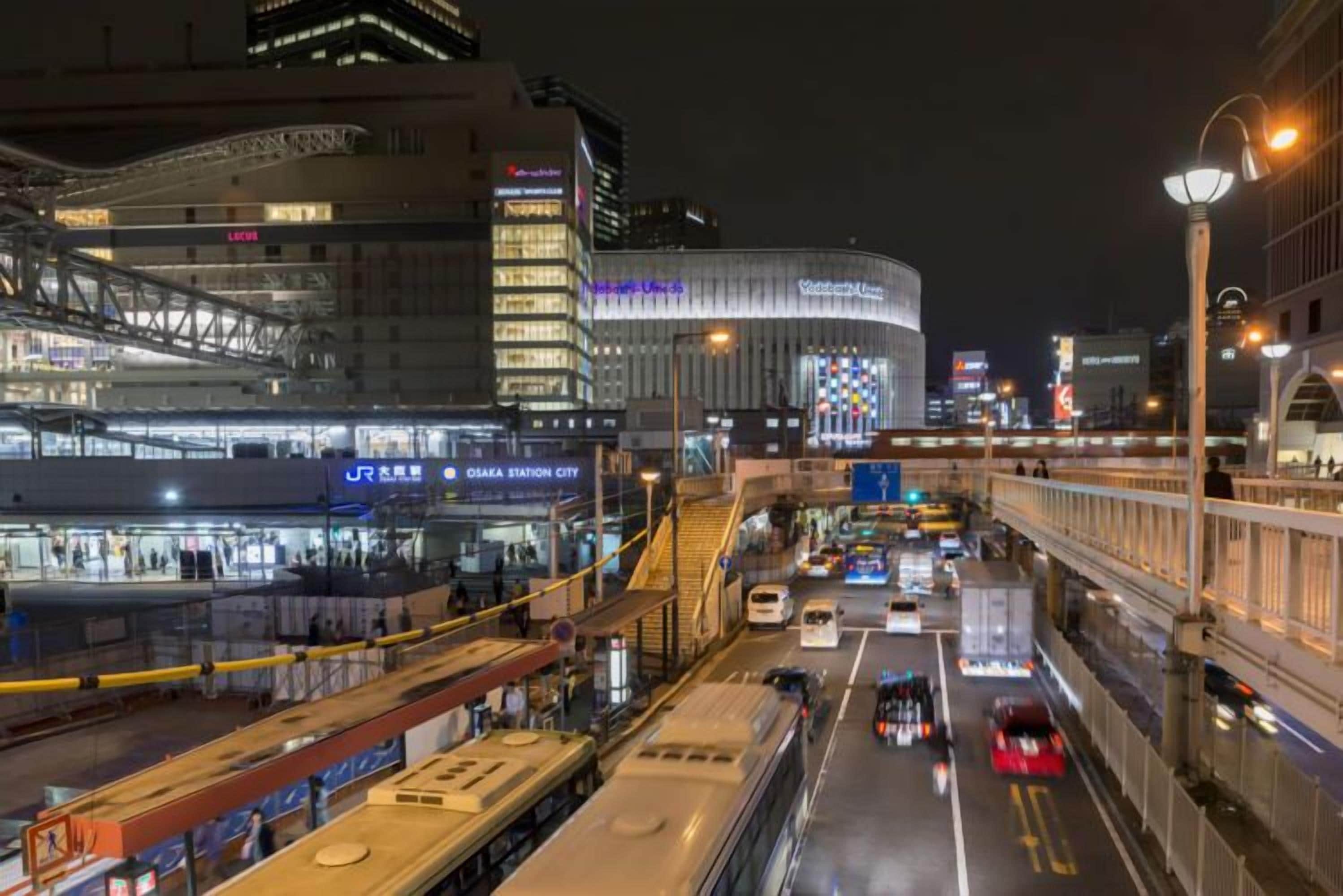 A multi-level urban transit station with modern architecture and signage for Osaka Station City.