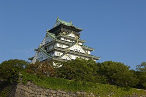 A traditional Japanese castle with multiple tiers, stone walls, and lush greenery. - Hiyori Hotel Osaka Suminoekoen Station (Osaka)