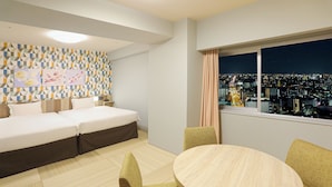 Quarto de hotel com cama, mesa de jantar e vista para a cidade.