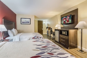 A hotel room with two beds, a desk, a television, a microwave, and a door leading to a bathroom. - Red Roof Inn Madison Heights, VA (Madison Heights)