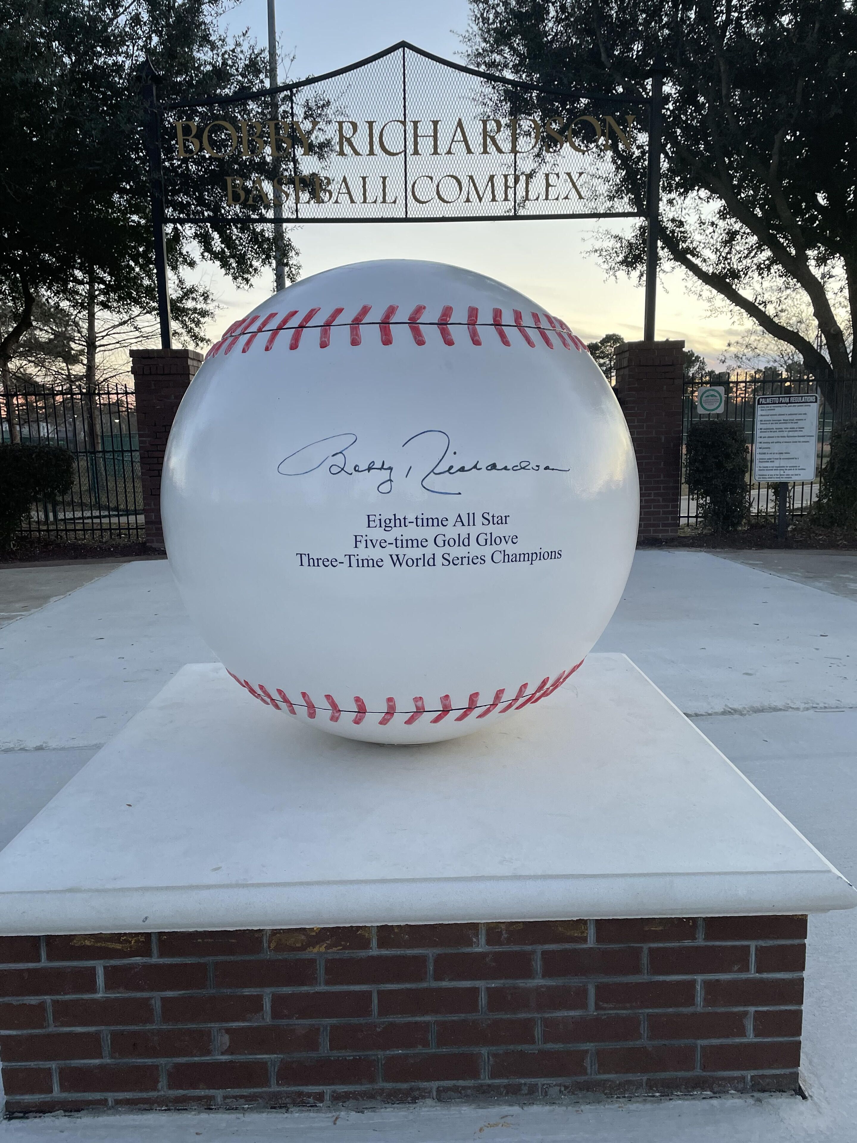 Een grote honkbal tentoongesteld met een plaquette waarop staat: 'Achtvoudig All-Star, Vijfvoudig Gold Glove, Drievoudig Wereldkampioen'.