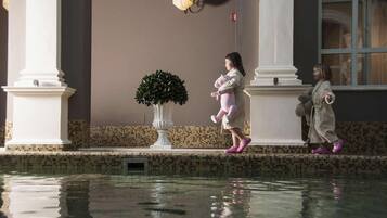 A pool area with tiled flooring and a potted plant.