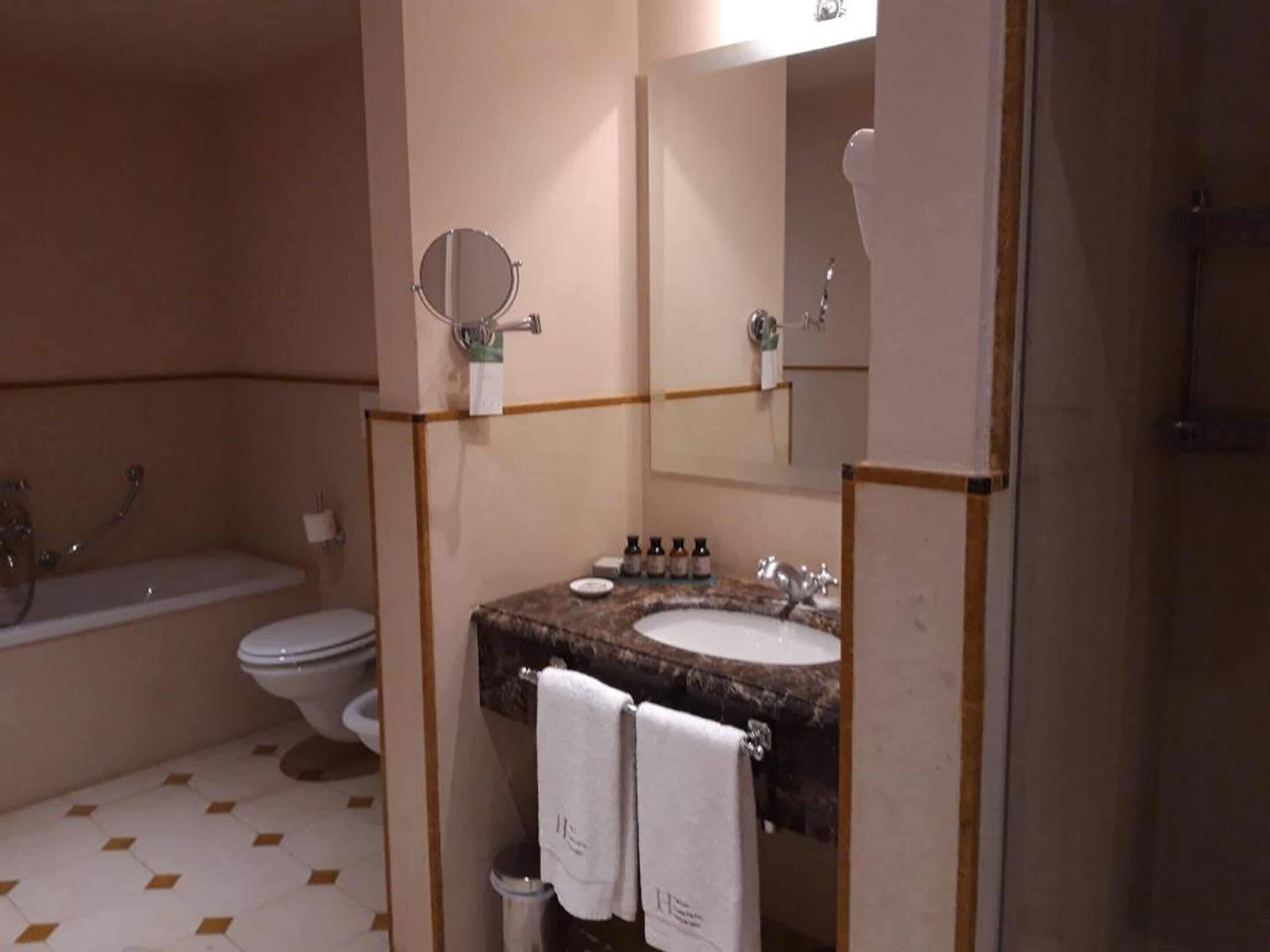 A bathroom with a toilet, sink, and bathtub.