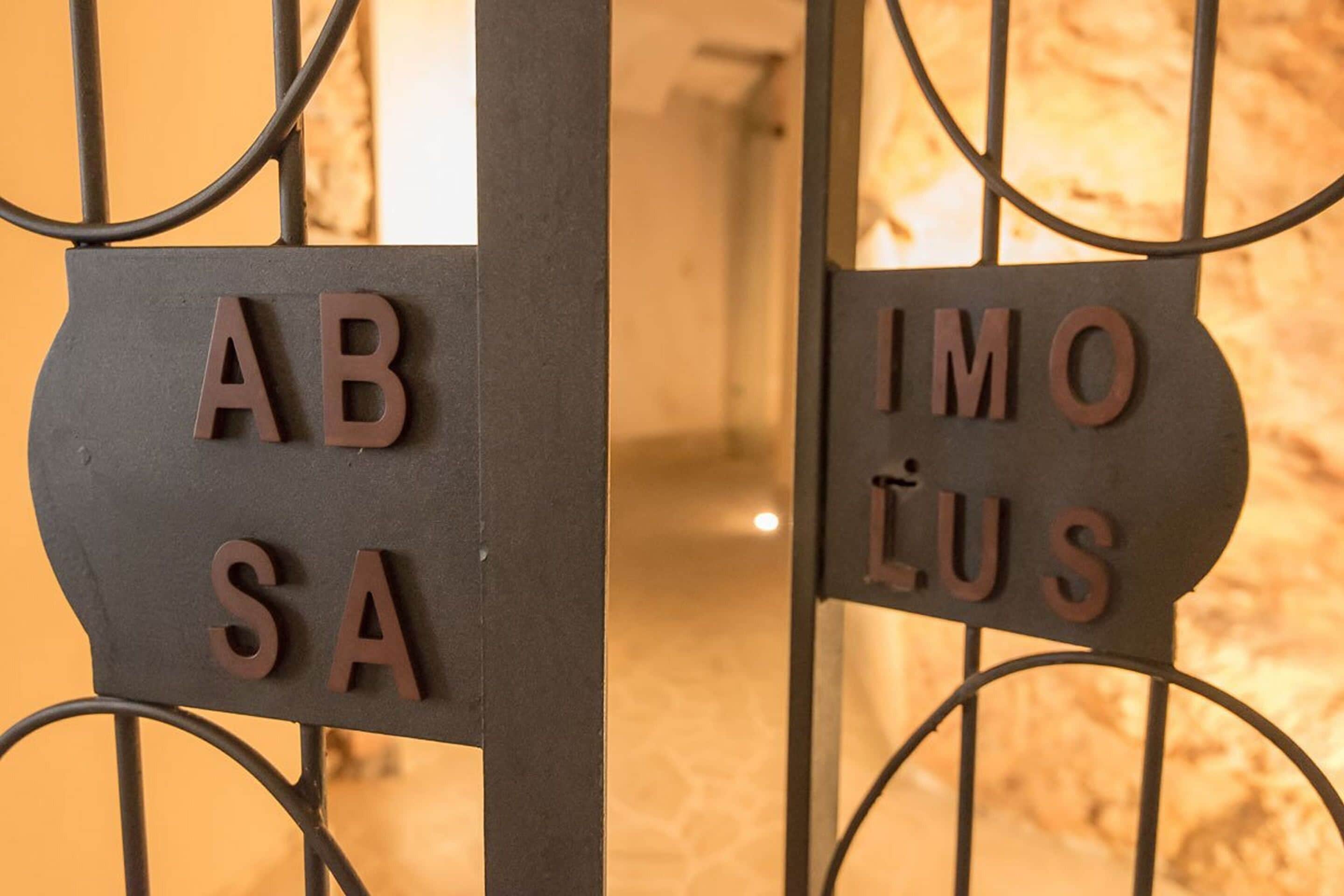 A metal gate with the words "AB SA IMO LUS" engraved on it.