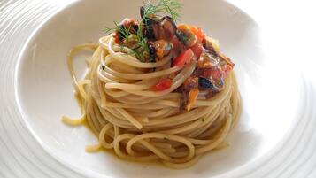 A plate of spaghetti with a tomato-based sauce and herbs.