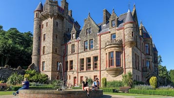 A historic stone building with multiple towers and a central courtyard.