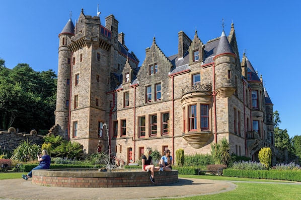 A historic stone building with multiple towers and a central courtyard.
