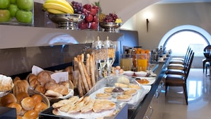 A buffet with various breads, pastries, fruits, and beverages. - c-hotels Fiume (Rome)