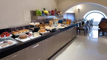 Un bufé de desayuno con diversos pasteles, frutas y bebidas.