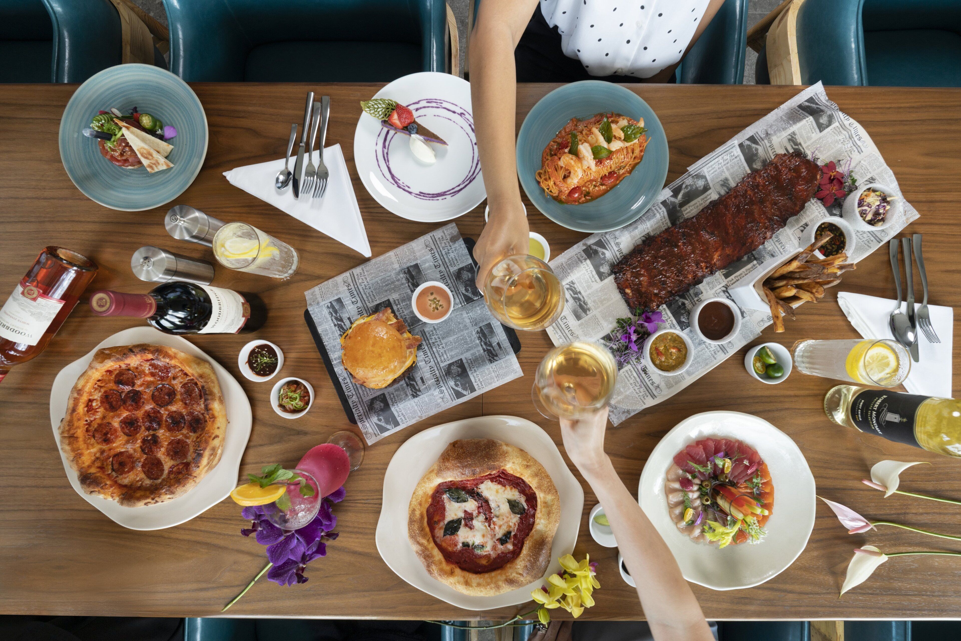 A dining table with various dishes, drinks, and condiments.