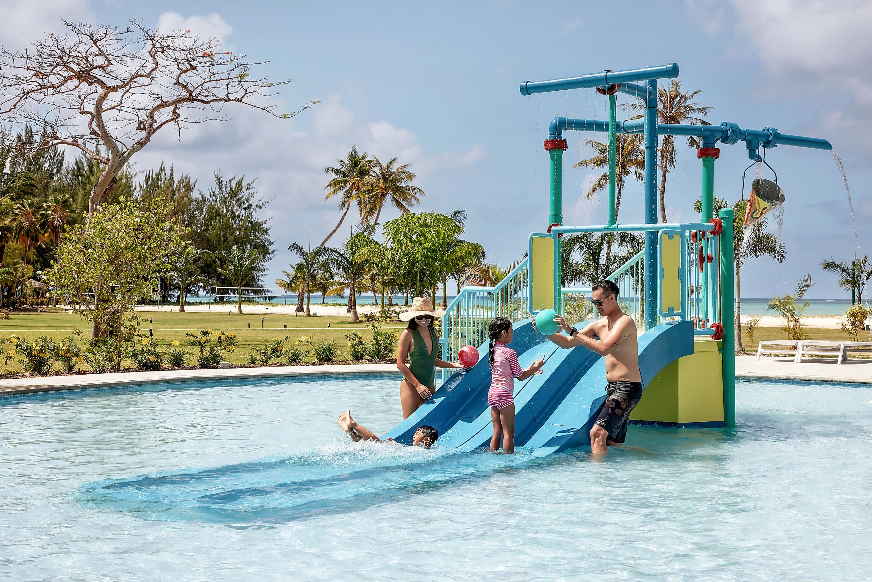 Un parco acquatico con uno scivolo blu e una piscina.