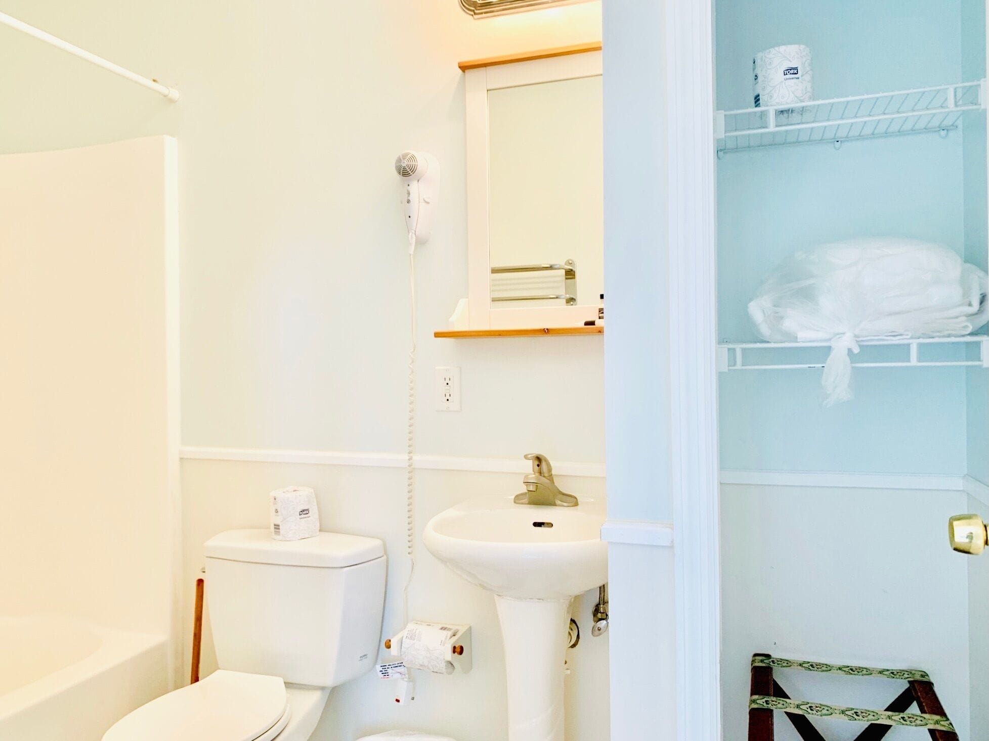 Un baño con inodoro, lavabo y toallero.
