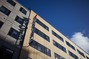 A multi-story building with a modern architectural design, featuring a series of windows and a visible fire escape. - CABINN Aarhus Hotel (Aarhus)