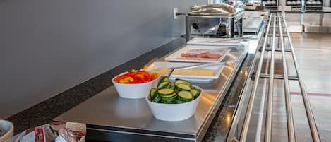 A buffet area with various food items and utensils.