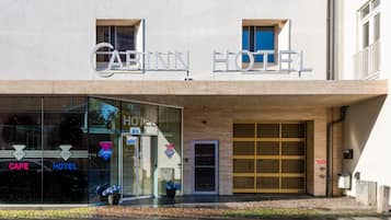 A building with a sign reading "Cabin Hotel" and a glass door entrance.