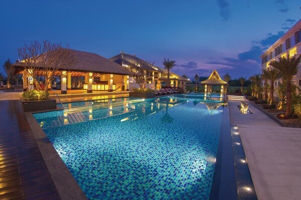 Alberca al aire libre, sombrillas en la alberca y camastros 