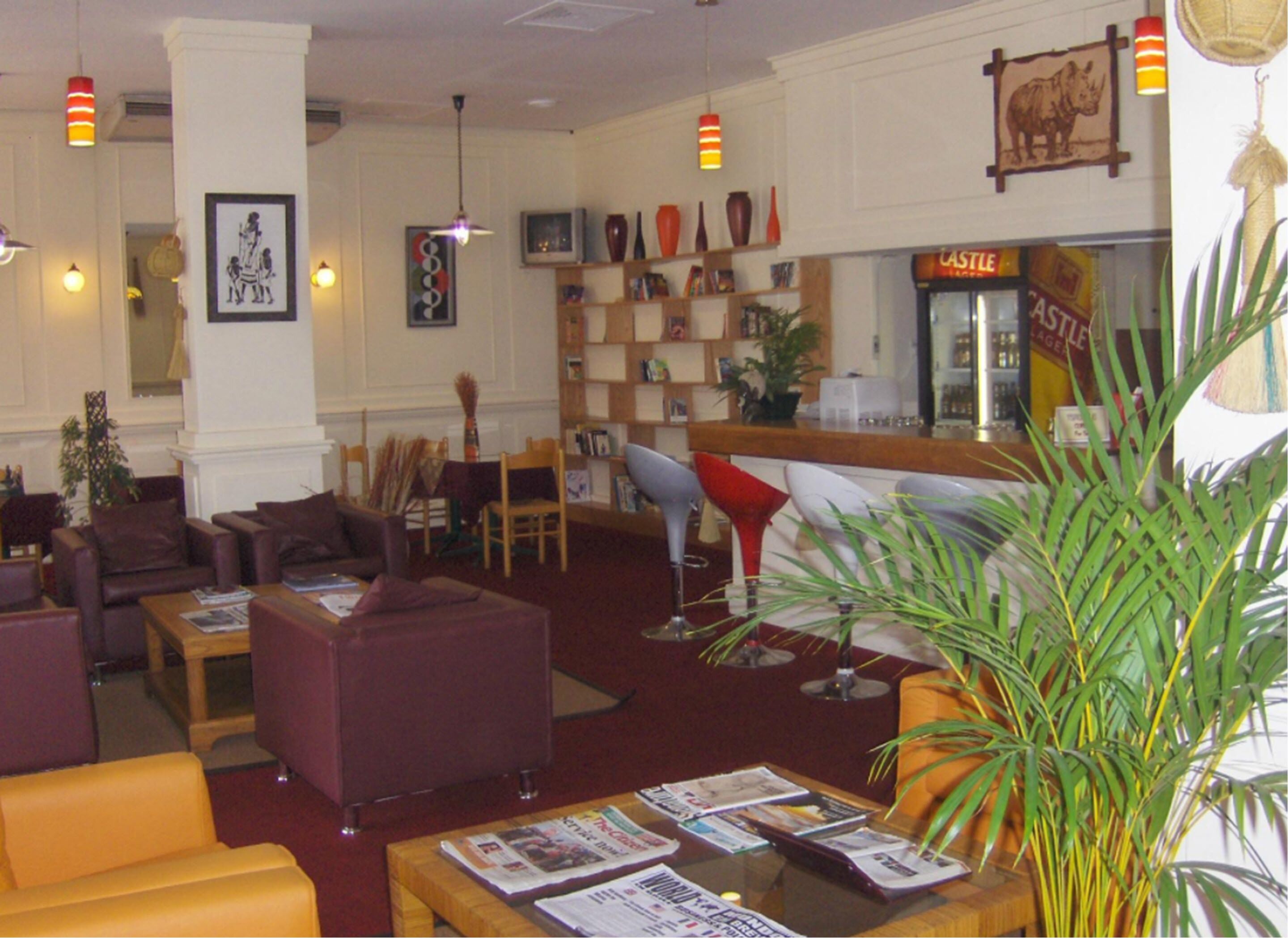 A hotel lobby with leather sofas, a bar area, and a variety of decorative items.