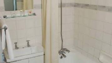 Un bagno con una vasca, un lavandino e uno specchio.