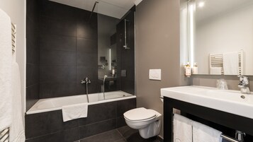 A modern bathroom with a bathtub, toilet, and sink.