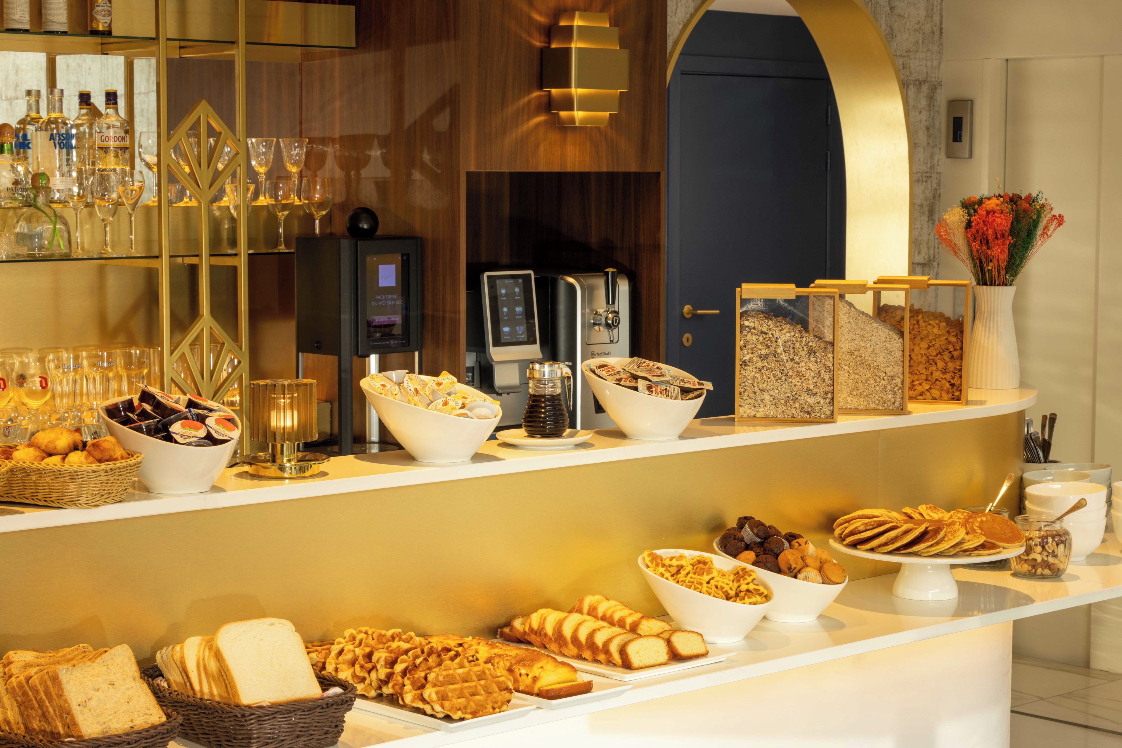 Un buffet proposant une variété de plats, notamment du pain, des pâtisseries et un coin café.