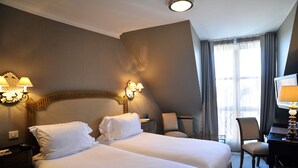 A hotel room with two beds, a desk, a chair, and a TV. - Hotel de la Treille (Lille)