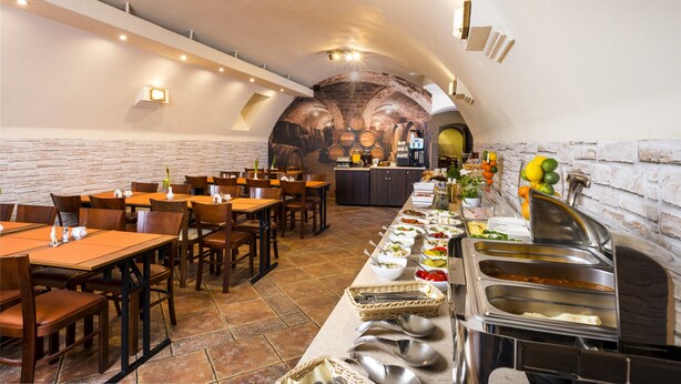 A restaurant with brick walls, wooden tables, and a buffet line with various dishes. - Hotel Regent (Kraków)
