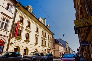 A historic building with a red sign indicating a hotel. - Hotel Regent (Kraków)