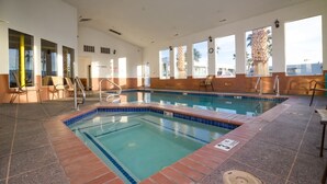 An indoor swimming pool with clear water, tiled edges, and a tiled deck area. - St. George Inn & Suites (St. George)