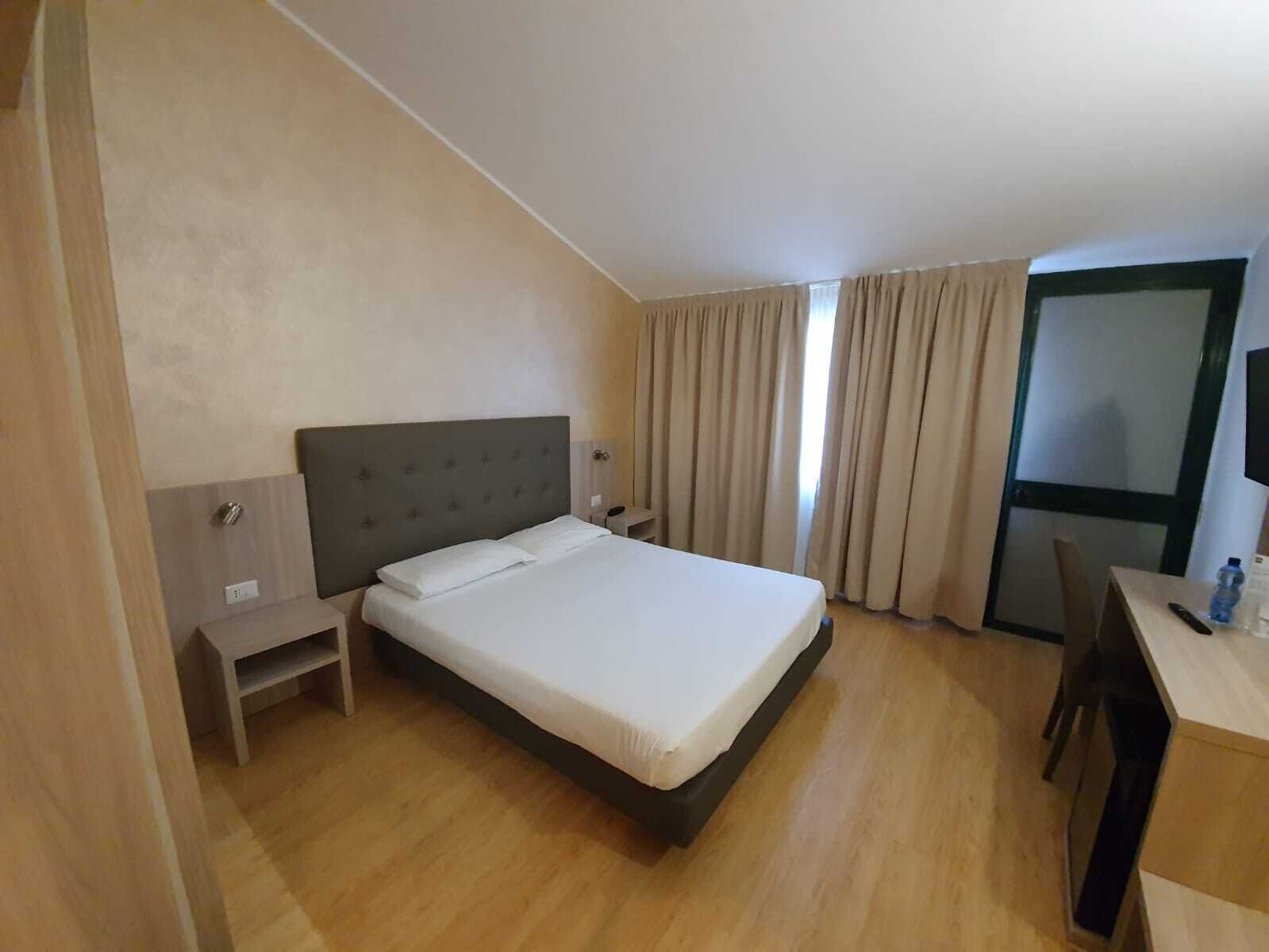 Ein Hotelzimmer mit einem Bett, einem Schreibtisch und einem Stuhl.