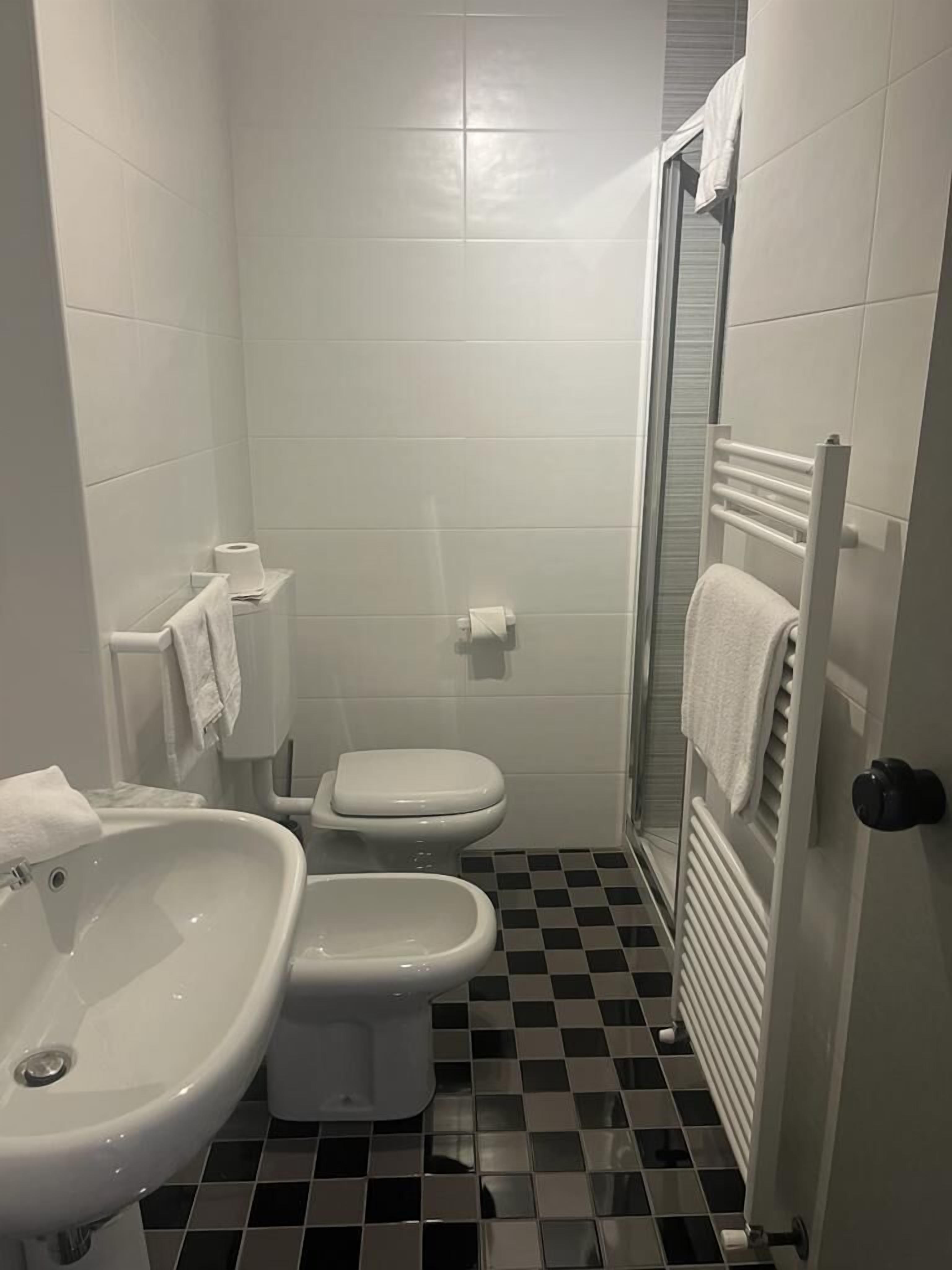 Un baño pequeño y moderno con bidé, inodoro y lavamanos.