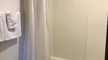 Un baño con cortina de ducha, inodoro y bañera.
