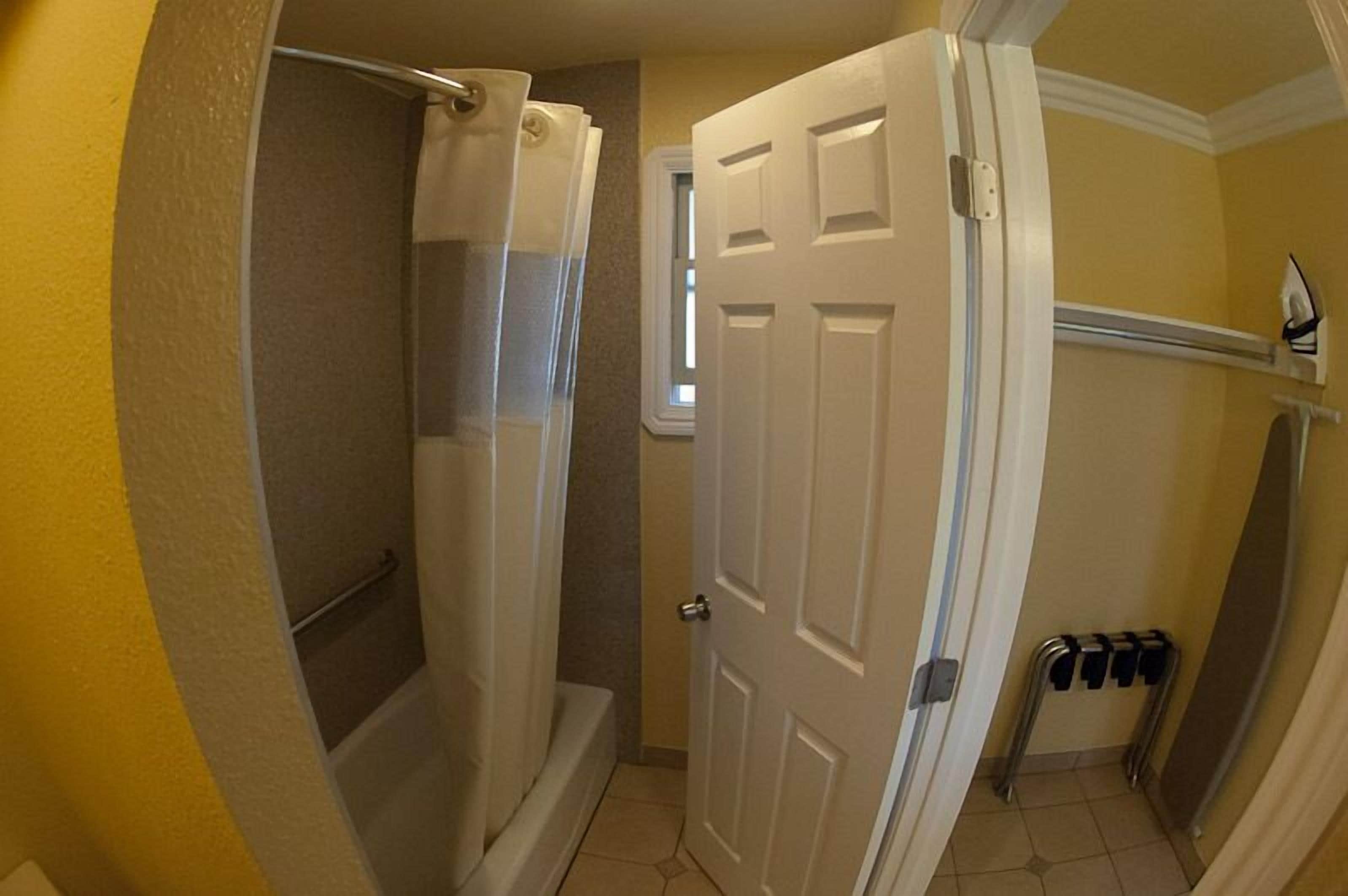A bathroom with a shower, a toilet, and a door.