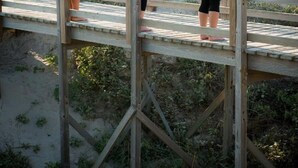 Three people performing yoga on a wooden bridge overlooking the ocean. - Port Royal Ocean Resort & Conference Center (Port Aransas)