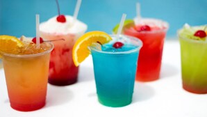 A variety of colorful drinks with straws and garnishes, including a blue drink with an orange slice and a cherry. - Port Royal Ocean Resort & Conference Center (Port Aransas)