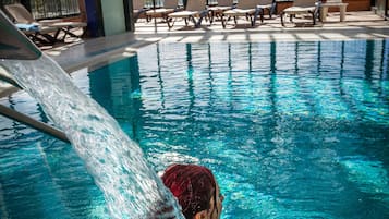 Piscine couverte, piscine avec cascade, chaises longues